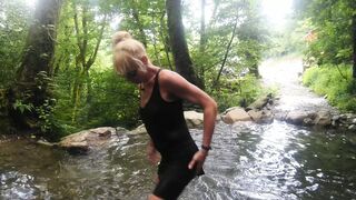 Alexa Cosmic trans girl swimming in font near waterfall wearing shorts and t-shirt...