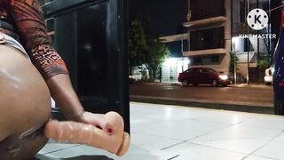 Limp sissy clitty dildoing her ass on the open door while cars pass by