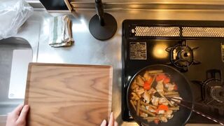 A man wearing pants makes sweet and spicy stew of chicken and burdock.